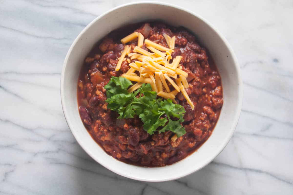 Easy Vegan Tofu Chili - A classic homemade dish made with spicy tofu crumbles topped with vegan cheese.