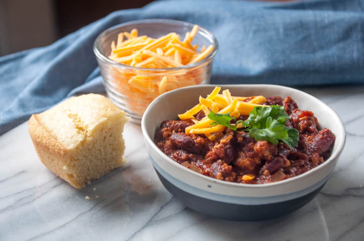 Easy Vegan Tofu Chili - A classic homemade dish made with spicy tofu crumbles topped with vegan cheese.