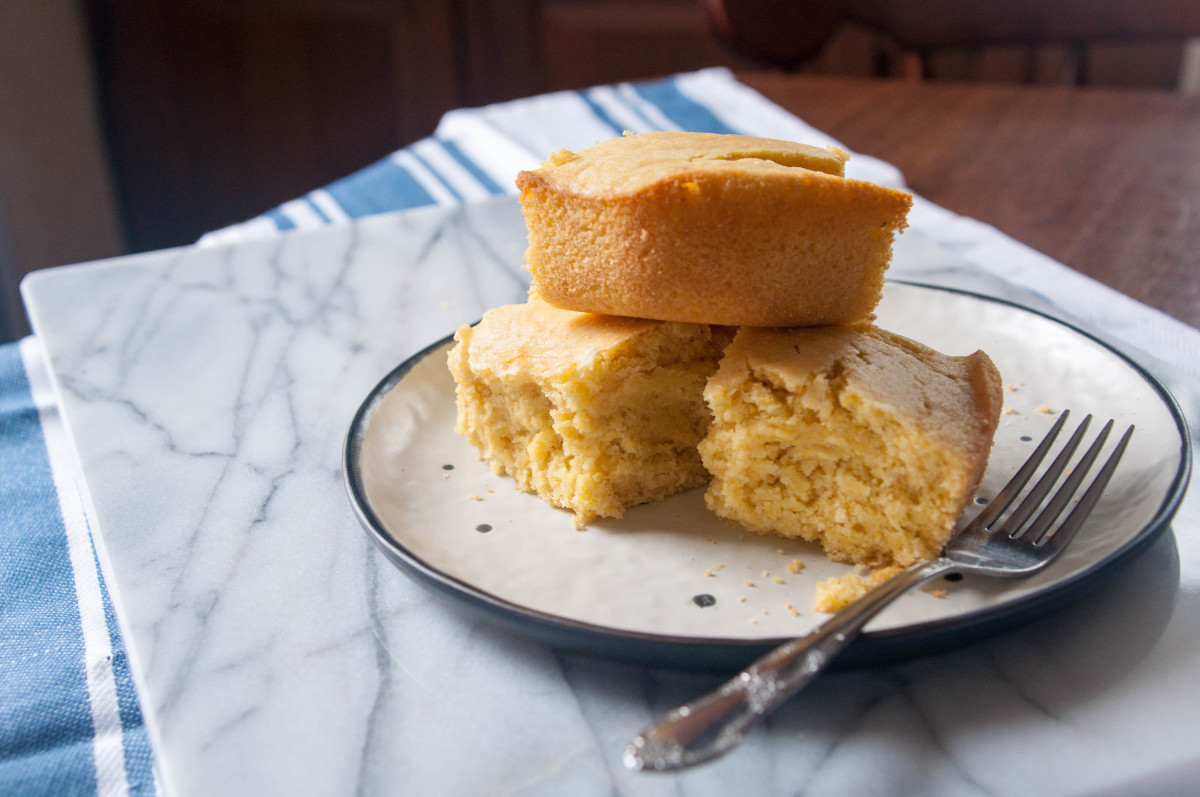 Stack of 3 vegan cornbread pieces on a plate with a fork