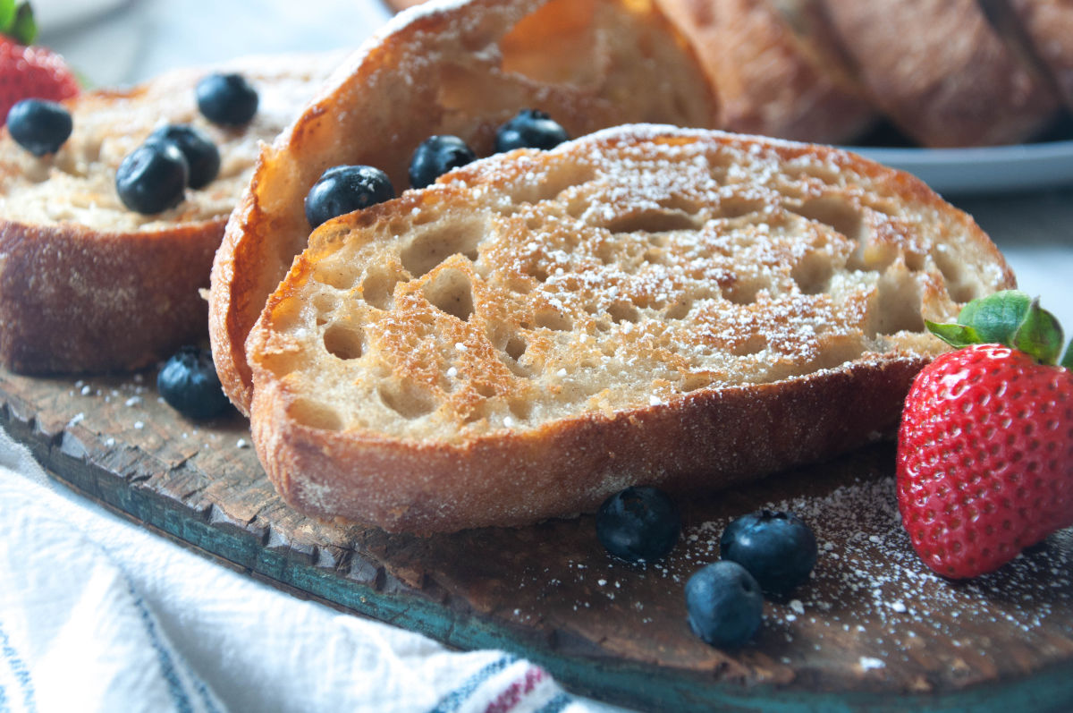 Vegan french toast slices on a wooden board with berries