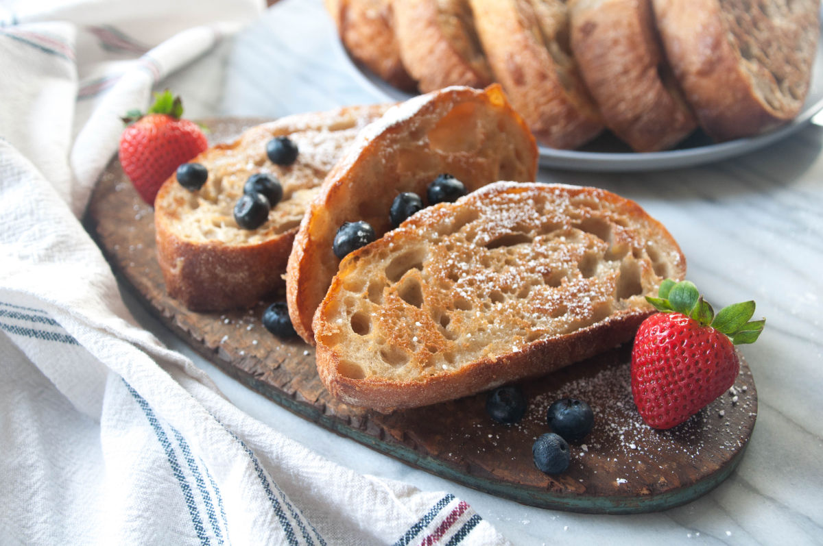 Vegan french toast slices on a wooden board with berries