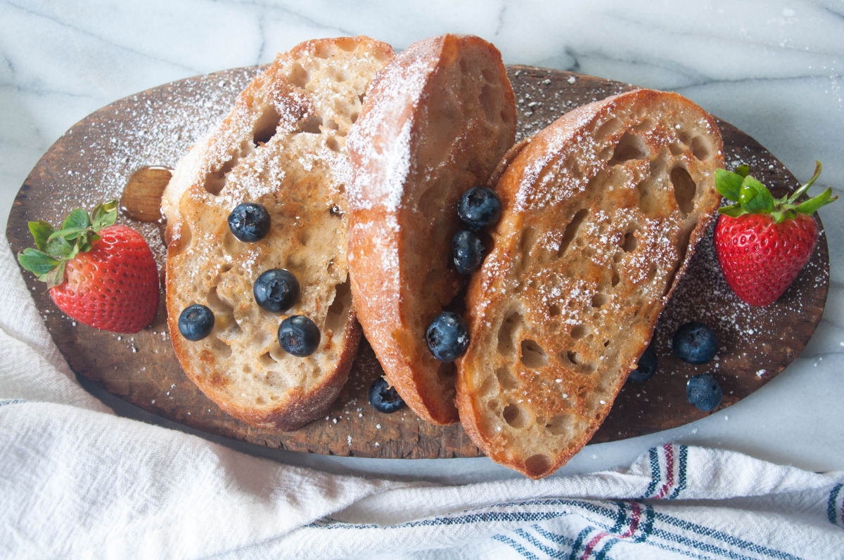 Vegan french toast slices on a wooden board with berries