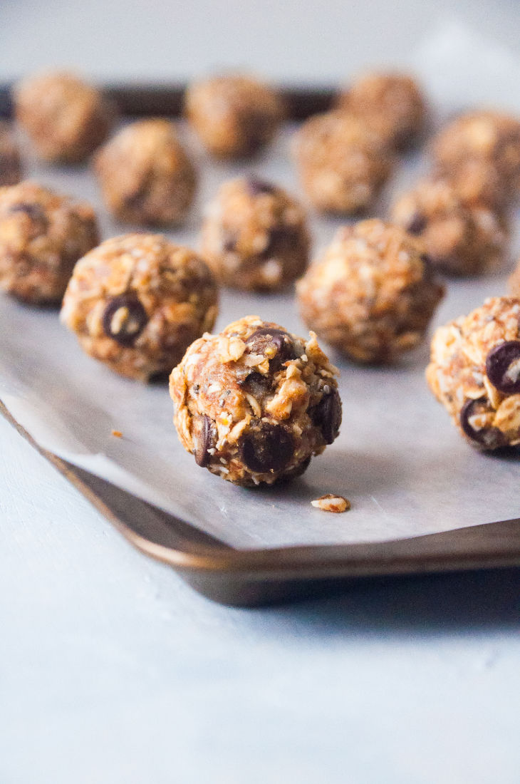 Close up of energy bites organized in lines on a lined baking sheet