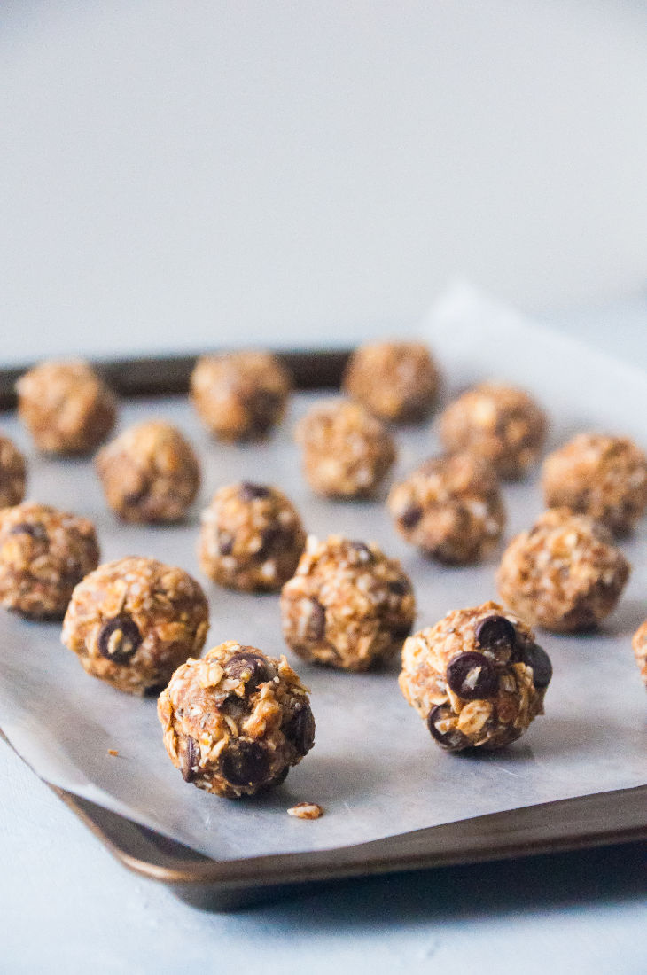 Energy bites organized in lines on a lined baking sheet