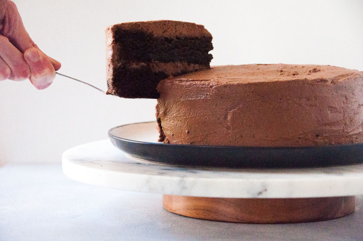 Vegan Chocolate Espresso Cake on a cake stand with a slice being taken out