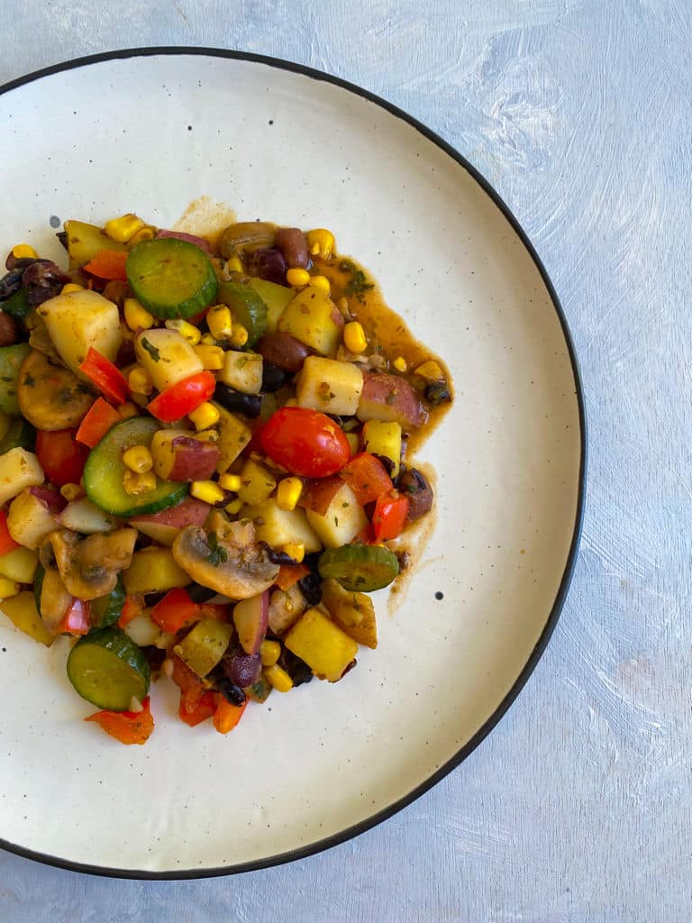 Cooked vegetable hash on a white plate