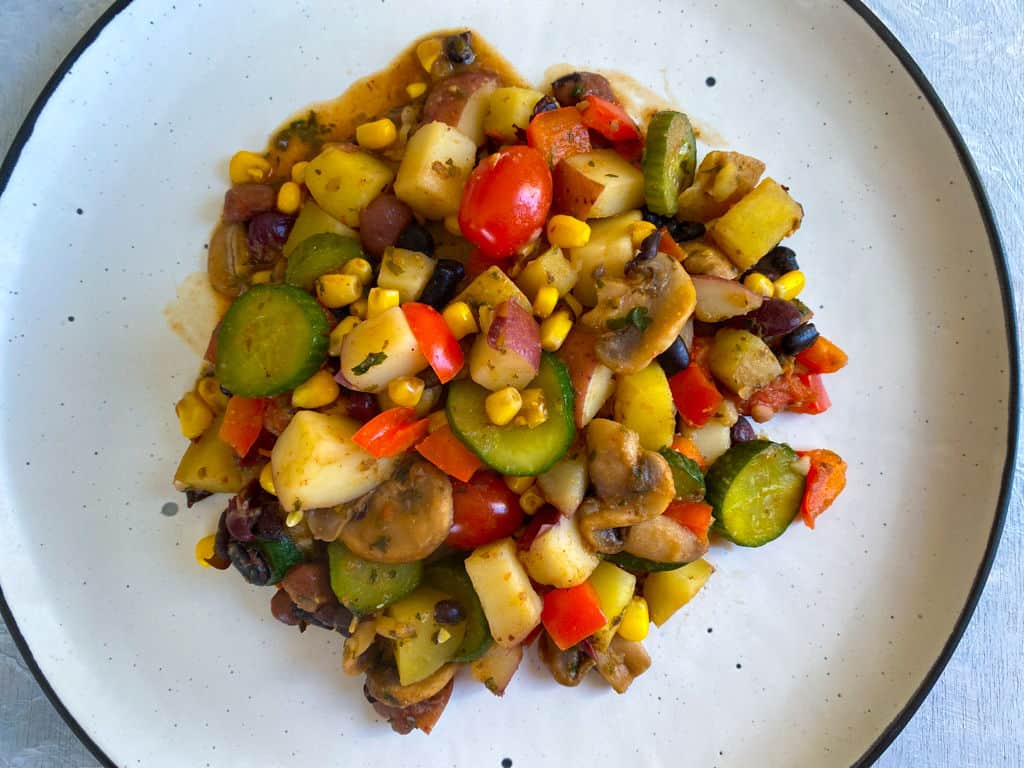 Cooked vegetable hash on a white plate